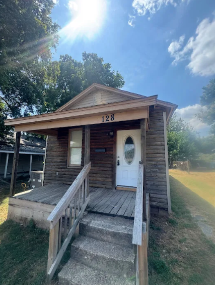A small wooden building with the number 128 on it.