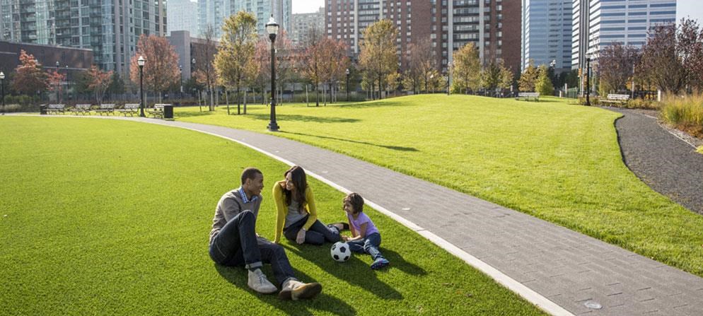a family playing with a soccer ball in a park