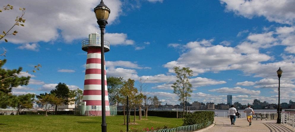 two people are walking near a lighthouse