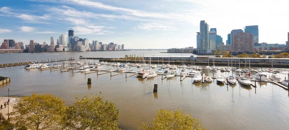 a harbor full of boats with a city in the background