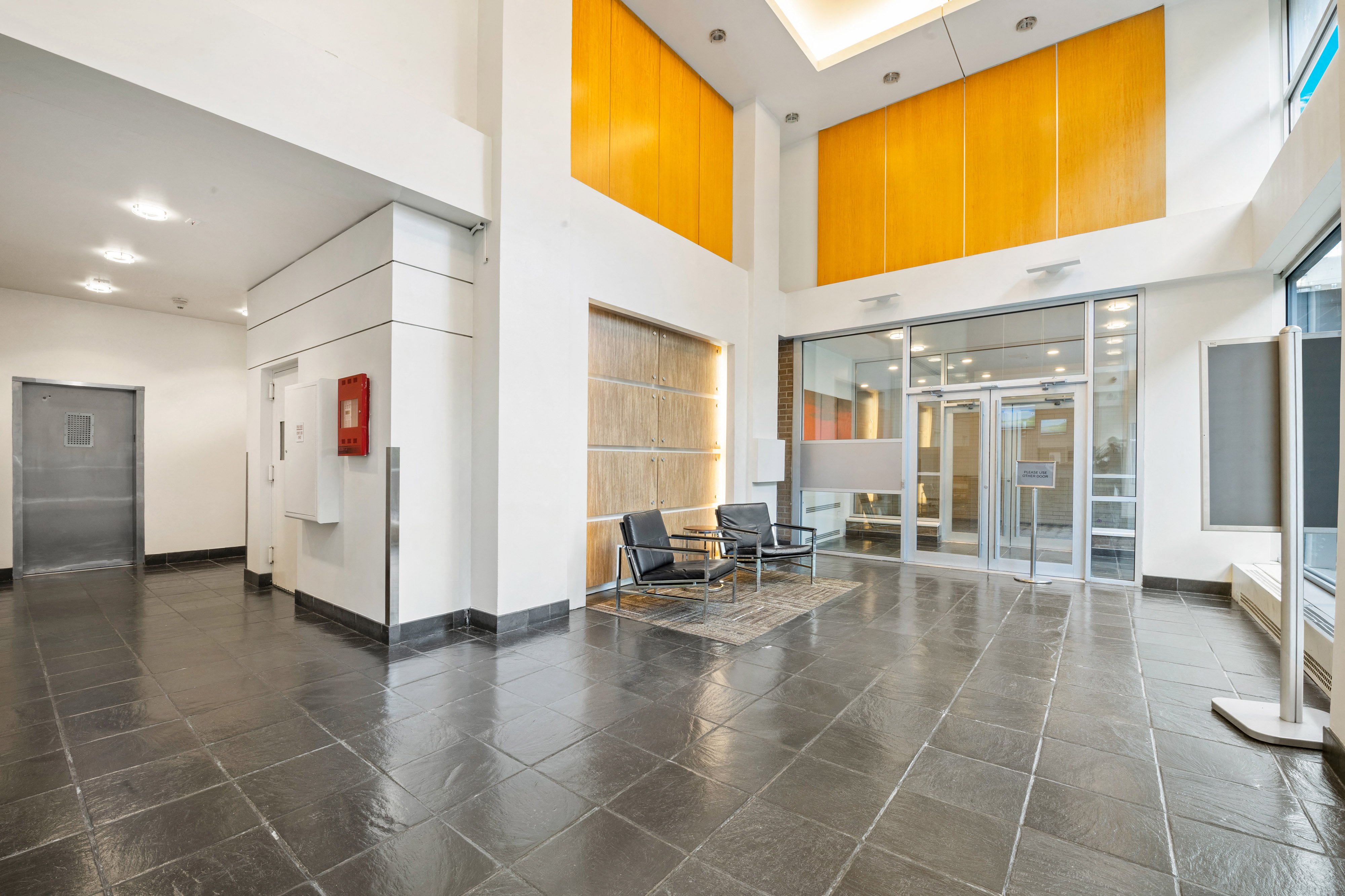 A hallway with a black floor and white walls.