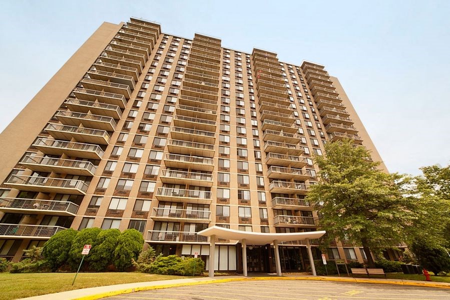 a tall building with many balconies and a street in front of it