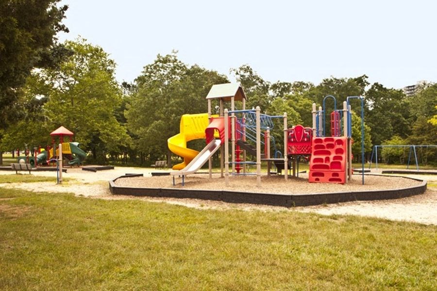 a playground with a yellow slide and red chairs