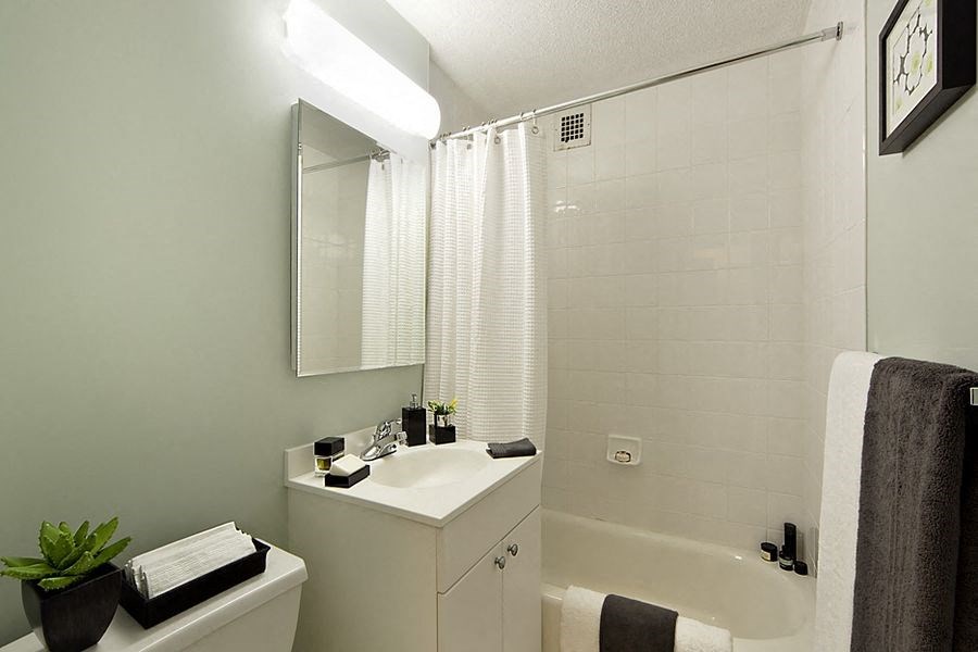 a white bathroom with a sink and a bath tub