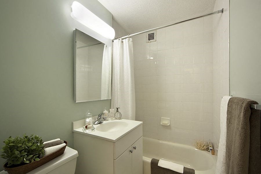 a white bathroom with a sink and a bath tub