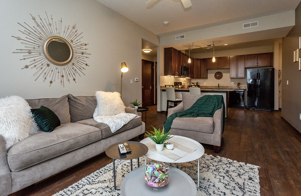 living room with couch, coffee table, unique artwork, and view into kitchen