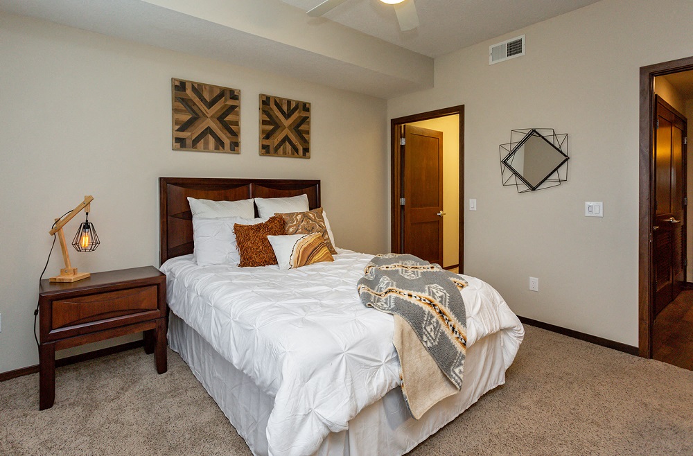 large bedroom with neutral artwork and a large walk-in closet