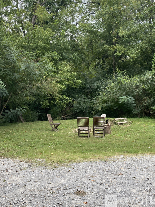 Two chairs are placed on a grassy area with trees in the background.