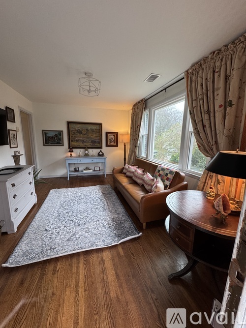 A living room with a couch, a table, and a rug.