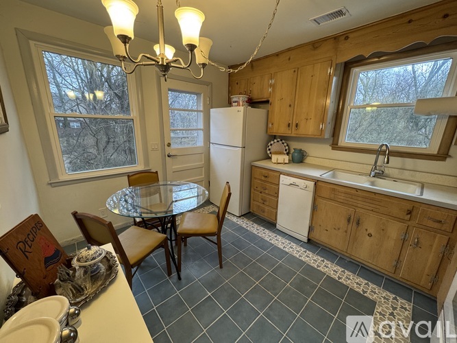 A kitchen with a table and chairs and a fridge.