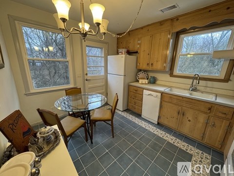 A kitchen with a table and chairs and a fridge.