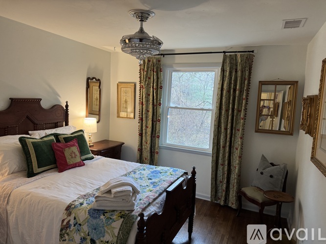 A bedroom with a large bed and a chandelier.