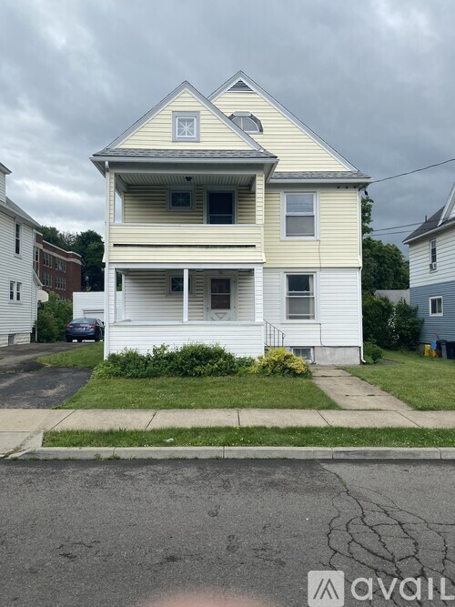 A two-story house with a white front and a grey roof.