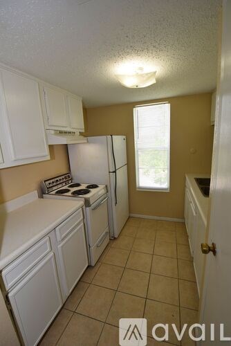A kitchen with white cabinets and a stove top oven.