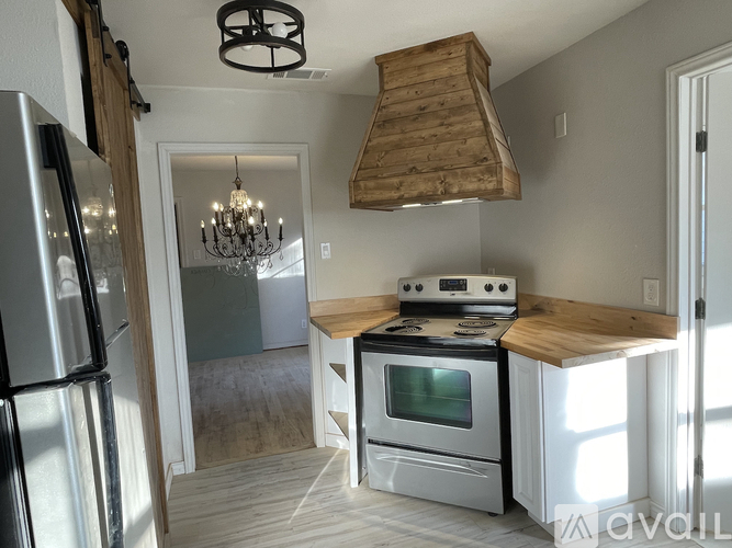 A kitchen with a stove and a refrigerator.