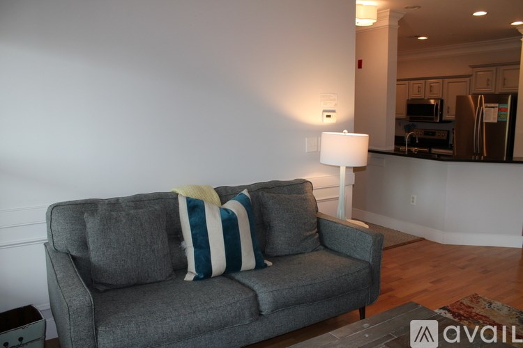 A grey couch with a striped pillow on it.