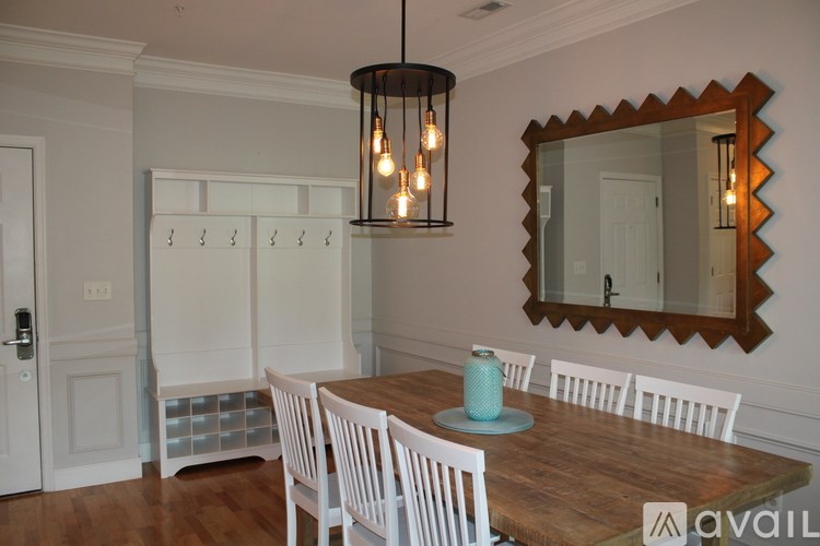 A dining room with a wooden table and white chairs.