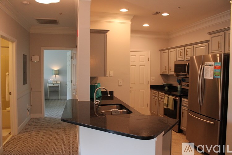 A kitchen with a black counter top and stainless steel appliances.