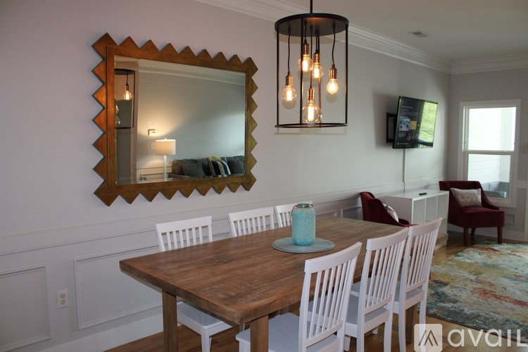 A dining room with a wooden table and chairs.