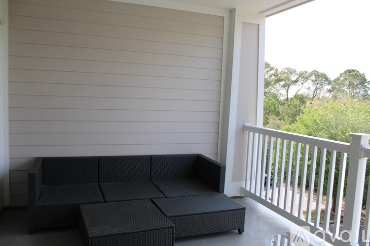A black wicker sofa on a porch.