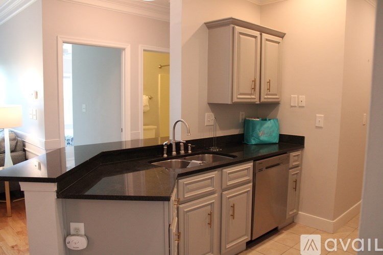 A kitchen with a black counter top and white cabinets.