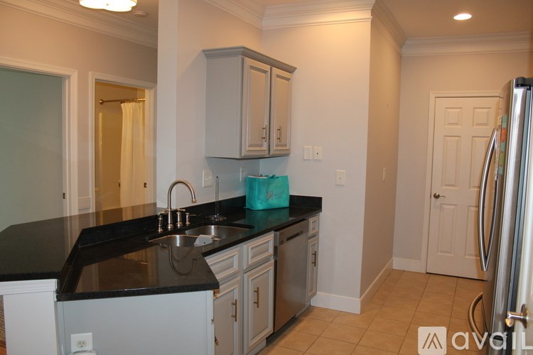 A kitchen with black countertops and white cabinets.
