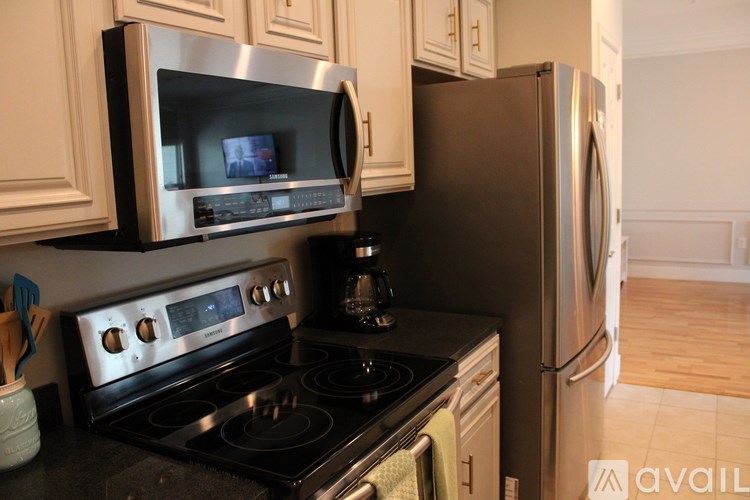 A kitchen with a stove, microwave, and refrigerator.