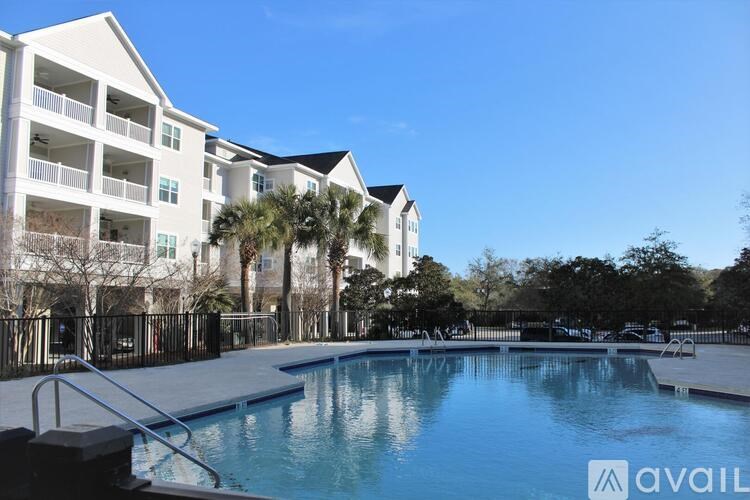 A large pool in front of a white apartment building.