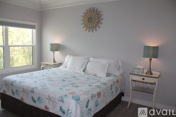 A bedroom with a bed, nightstand, and window.