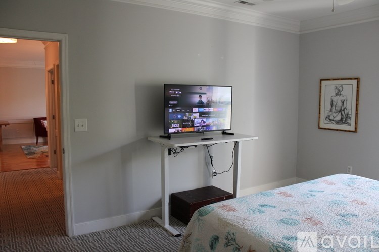A television is on a stand in a bedroom.