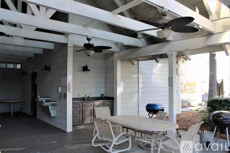 A patio with a table and chairs under a roof.