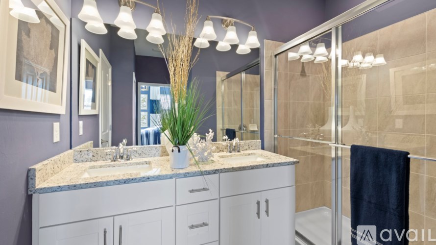 A bathroom with a marble countertop and a large mirror.