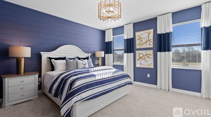 A bedroom with a large bed and a chandelier.