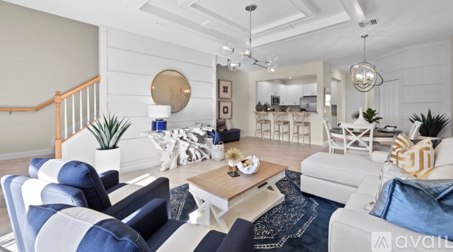 A living room with a white couch, a coffee table, and a rug.