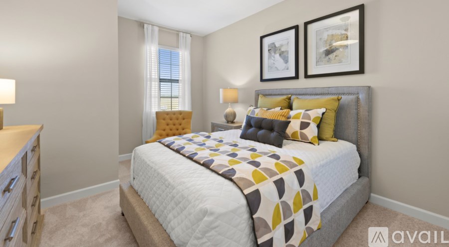 A bedroom with a large bed and two framed pictures on the wall.
