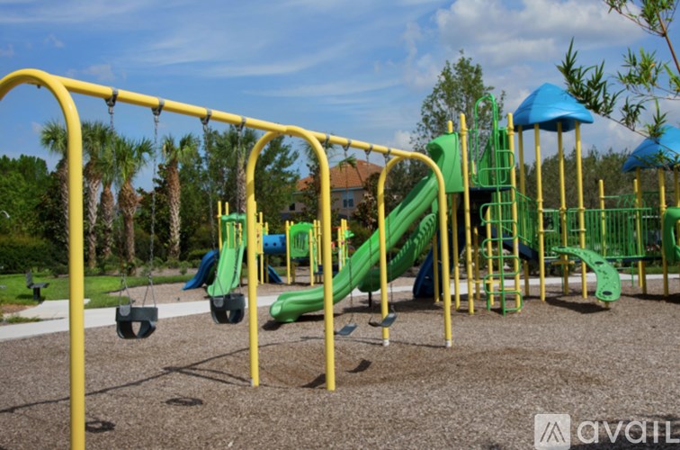 A playground with a yellow swing set and green slides.