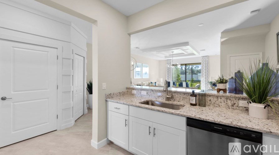 A modern kitchen with white cabinets and a granite countertop.