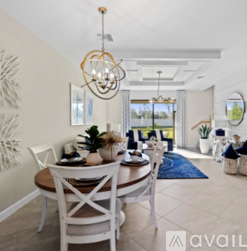 A dining room with a wooden table and white chairs.