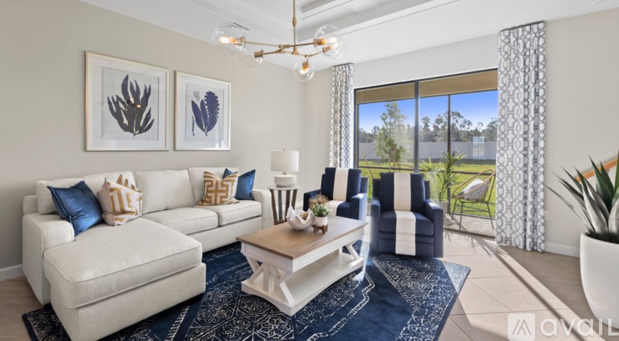 A living room with a white sofa, a coffee table, and a chandelier.