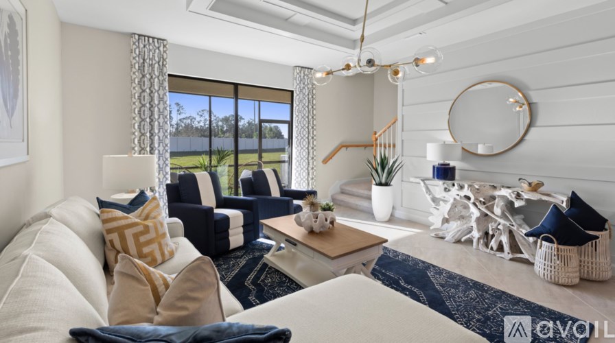 A living room with a white couch and a blue rug.
