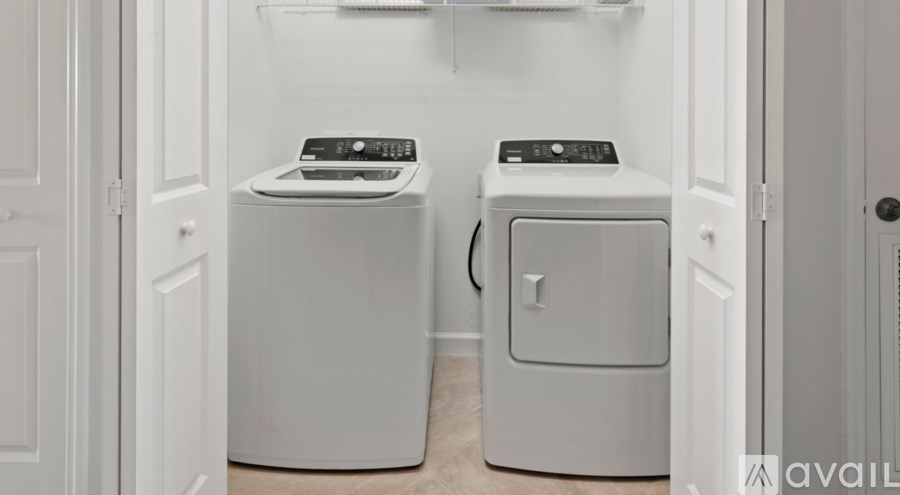 Two white front loading washing machines in a laundry room.