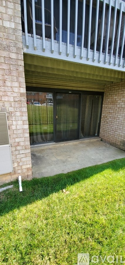 A balcony with white railings and a glass door.
