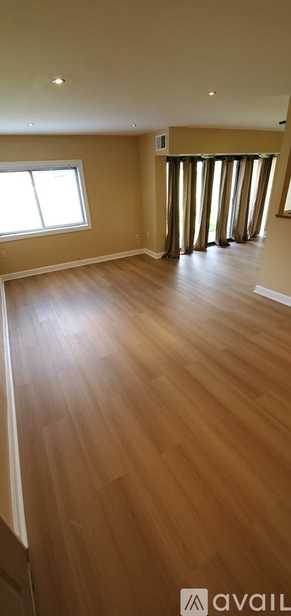 A room with wooden flooring and a window.