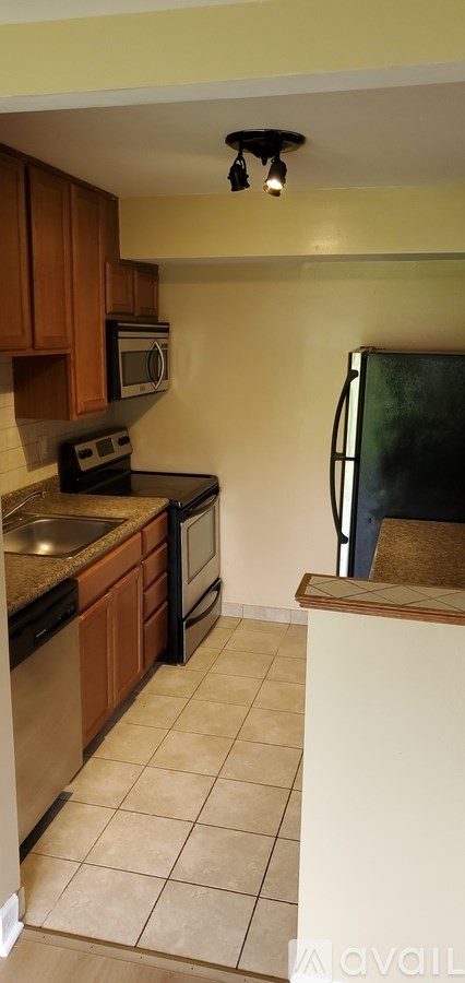 A kitchen with wooden cabinets and a black stove top oven.