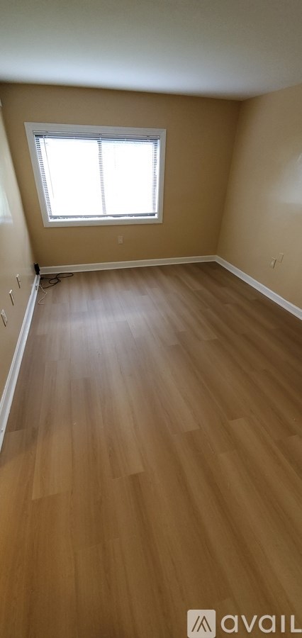 A room with wooden flooring and a window.
