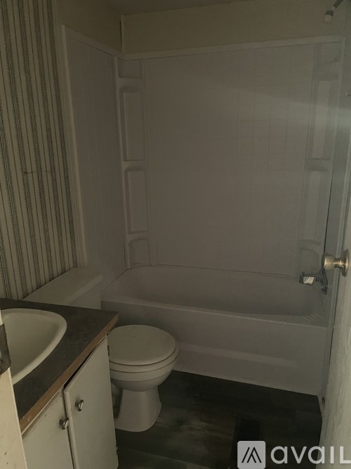 A bathroom with a toilet, sink, and bathtub.