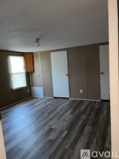 A room with wooden flooring and a window.