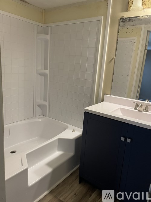 A bathroom with a white tub and a white sink.