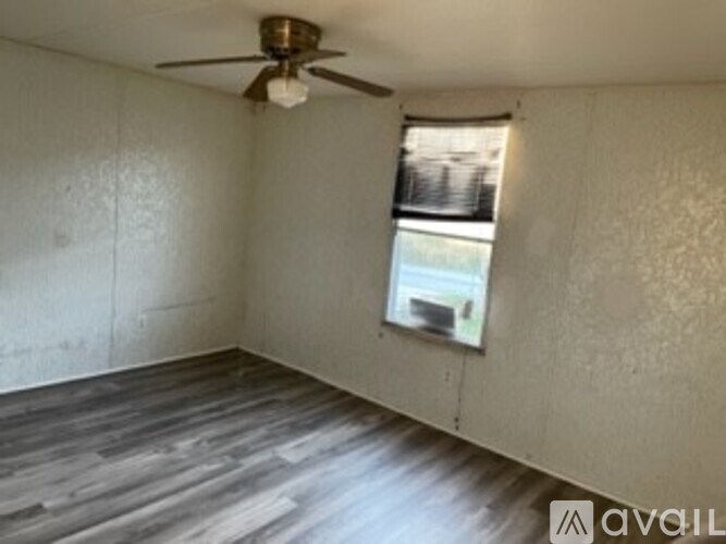 A room with a ceiling fan and a window.