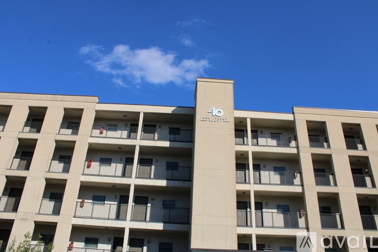 A tall building with balconies and a logo on the side.